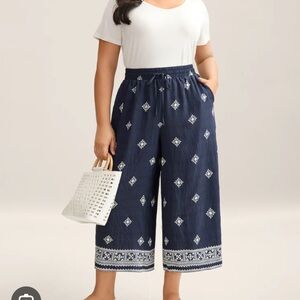 BloomChic embroidered wide-leg border print pants in navy blue.